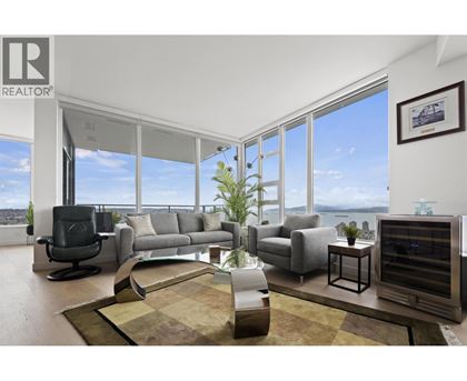 A living room with a large window overlooking the water.