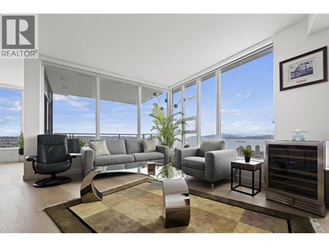 A living room with a large window overlooking the water.