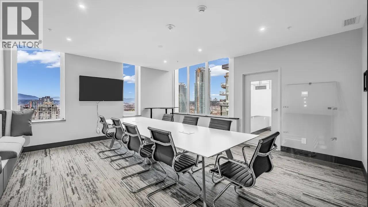 A conference room with a long table and chairs.
