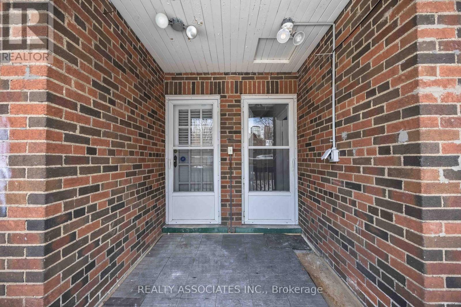 A white door is on the brick wall of a house.