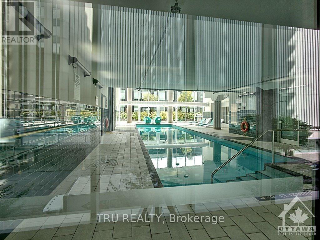 A TRU Realty Brokerage sign is displayed in a glass-walled office with a pool.