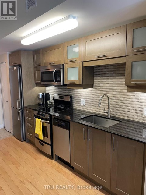 A kitchen with wooden cabinets and a black countertop.