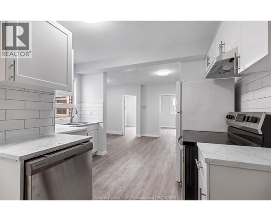 A kitchen with a stainless steel dishwasher and a white countertop.