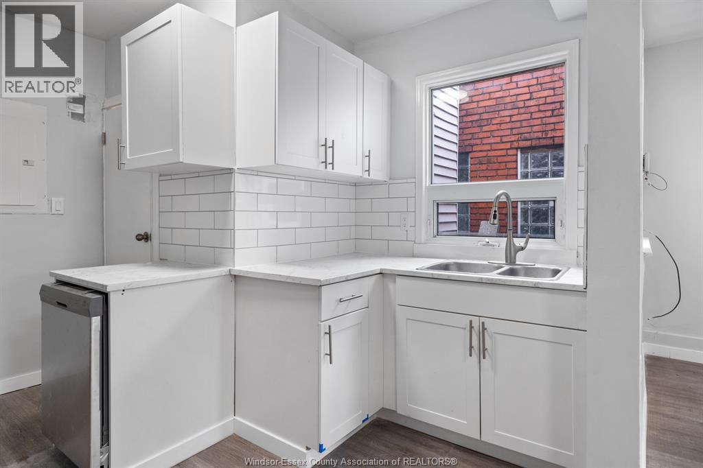 A kitchen with white cabinets and a window.
