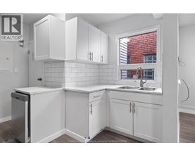 A kitchen with white cabinets and a window.
