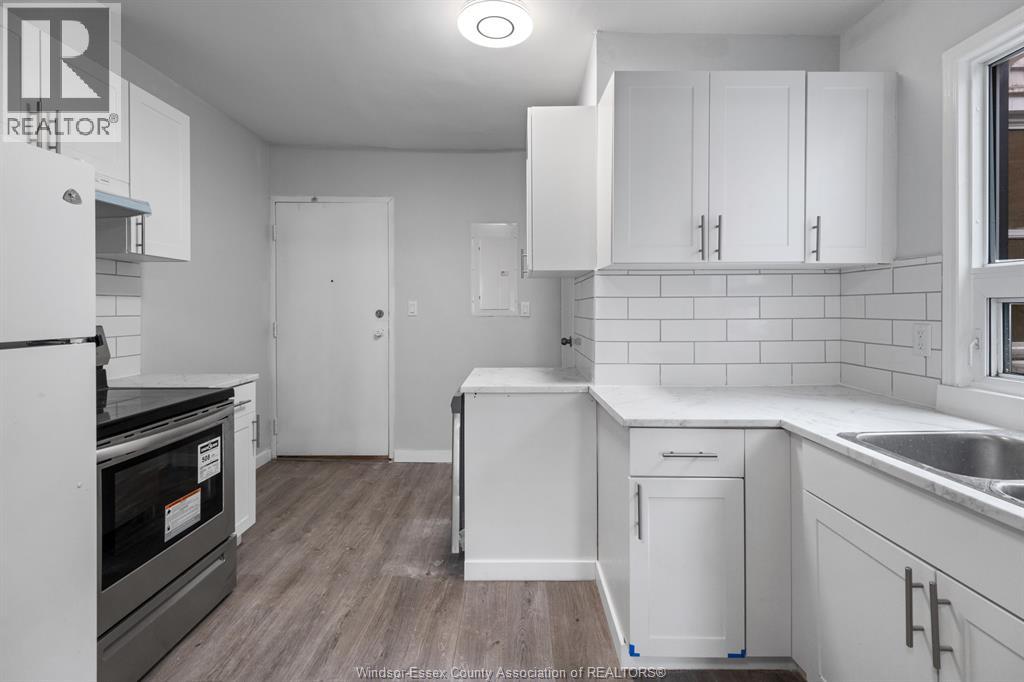 A kitchen with white cabinets and a black oven.