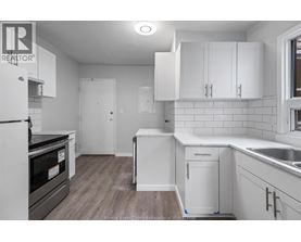 A kitchen with white cabinets and a black oven.