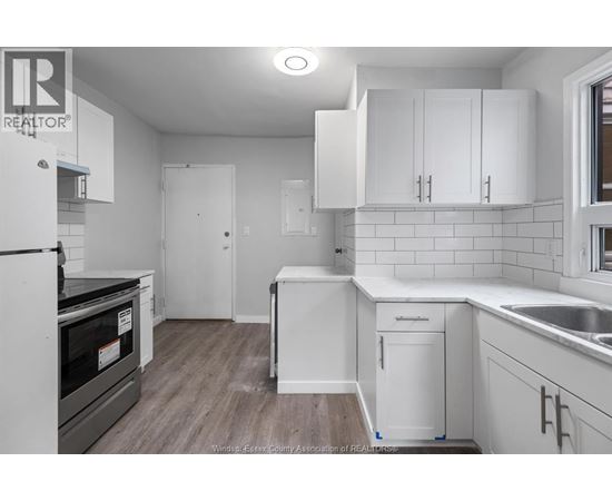 A kitchen with white cabinets and a black oven.