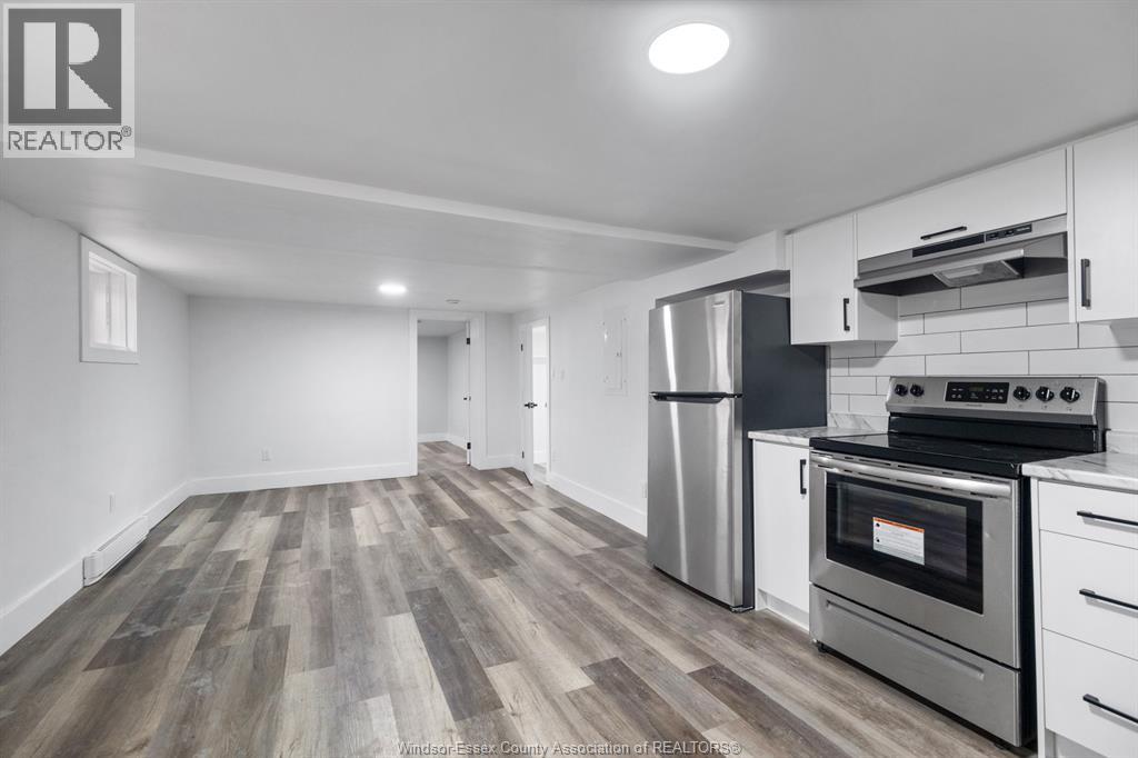 A kitchen with a stove top oven and a refrigerator.