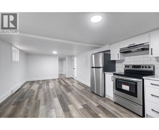 A kitchen with a stove top oven and a refrigerator.