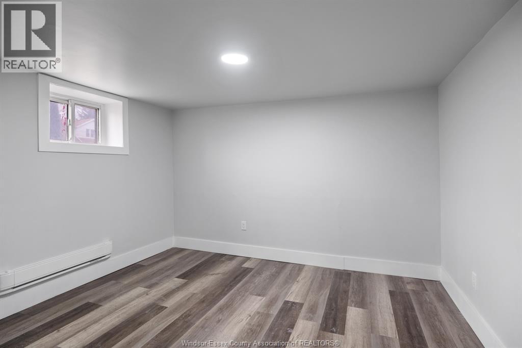 A room with wooden flooring and a window.