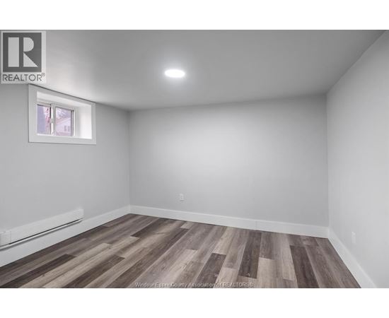 A room with wooden flooring and a window.