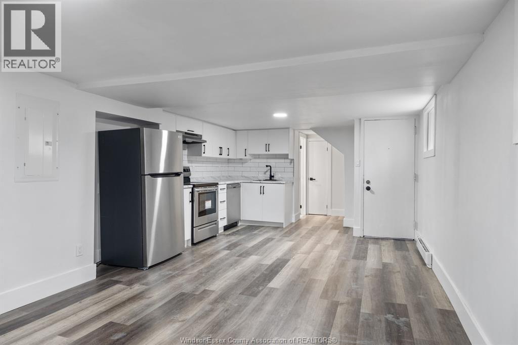 A kitchen with white cabinets and a stainless steel refrigerator.