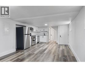 A kitchen with white cabinets and a stainless steel refrigerator.