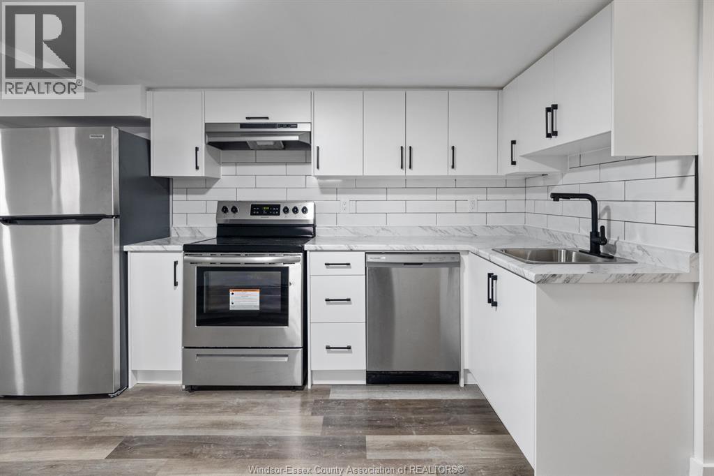 A modern kitchen with white cabinets and stainless steel appliances.