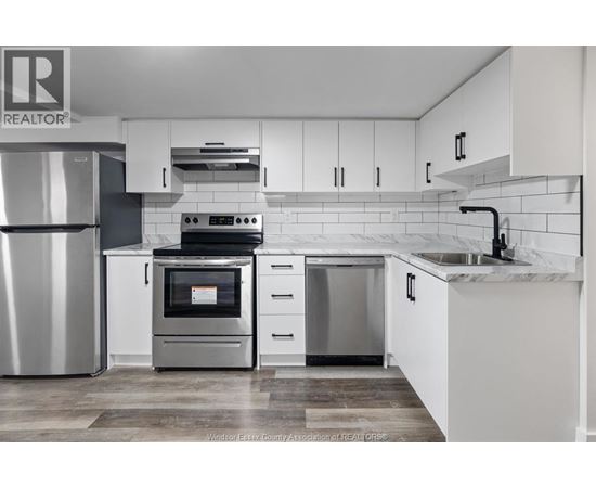 A modern kitchen with white cabinets and stainless steel appliances.