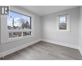 A room with a large window and a smaller window on the wall.