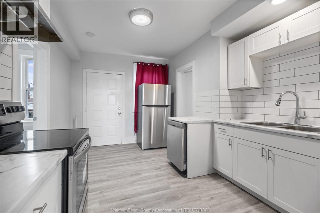 A kitchen with white cabinets and a black counter top.