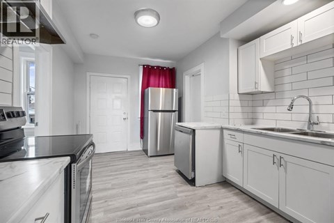 A kitchen with white cabinets and a black counter top.