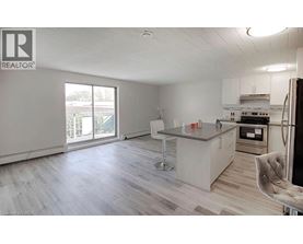 A kitchen with a refrigerator, sink, and stove.