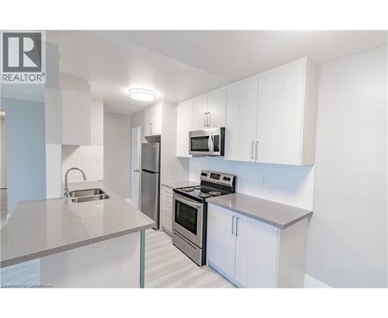 A modern kitchen with white cabinets and stainless steel appliances.