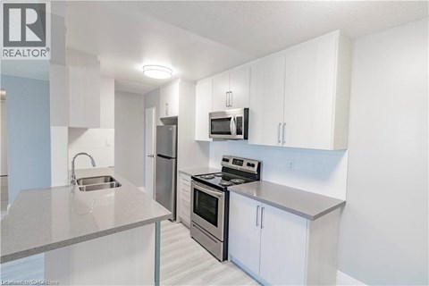 A modern kitchen with white cabinets and stainless steel appliances.