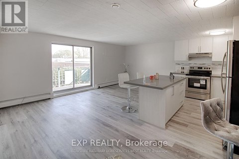 A kitchen with a bar stool and a chair in front of it.