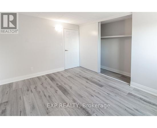 A room with a white door and a glass window with a wooden floor.