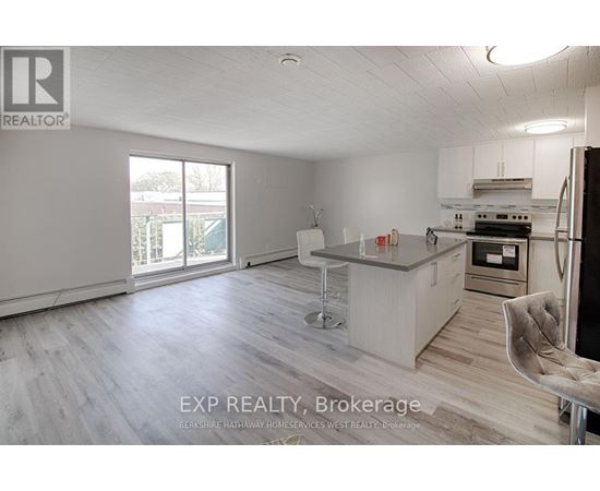 A kitchen with a bar stool and a chair in front of it.