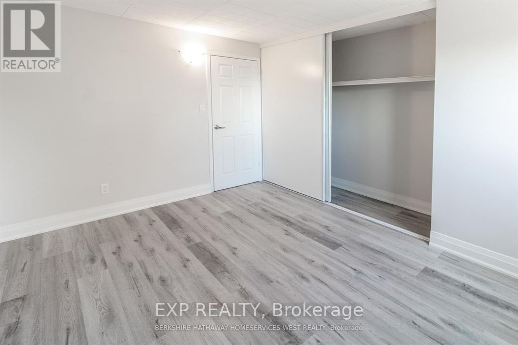 A room with a white door and a glass window with a wooden floor.