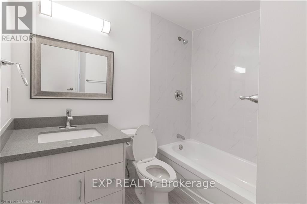 A bathroom with a toilet, sink, and bathtub.
