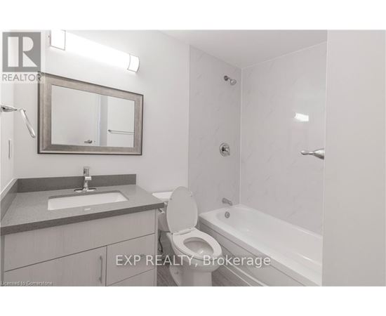 A bathroom with a toilet, sink, and bathtub.