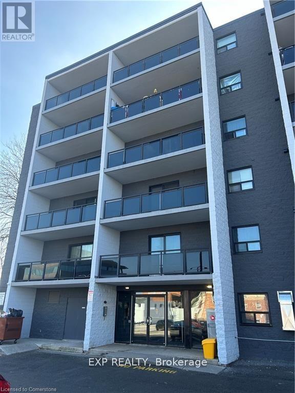 A tall apartment building with a balcony on the second floor.