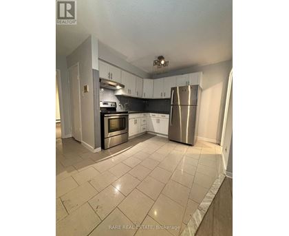 A kitchen with white cabinets and a stainless steel refrigerator.