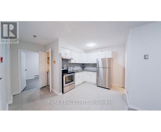 A kitchen with white cabinets and a stainless steel refrigerator.