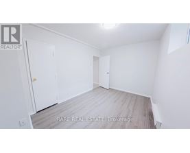 A small white refrigerator in a narrow hallway.