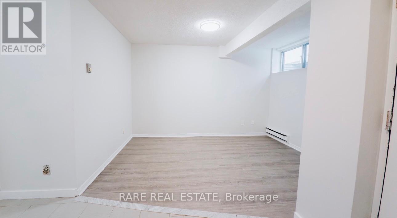 A white room with a wooden floor and a window.