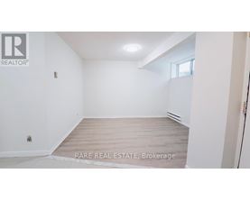 A white room with a wooden floor and a window.