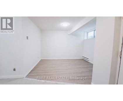 A white room with a wooden floor and a window.