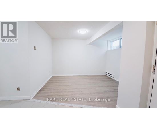 A white room with a wooden floor and a window.