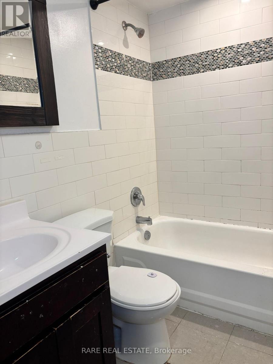 A white toilet sits next to a bathtub in a bathroom.