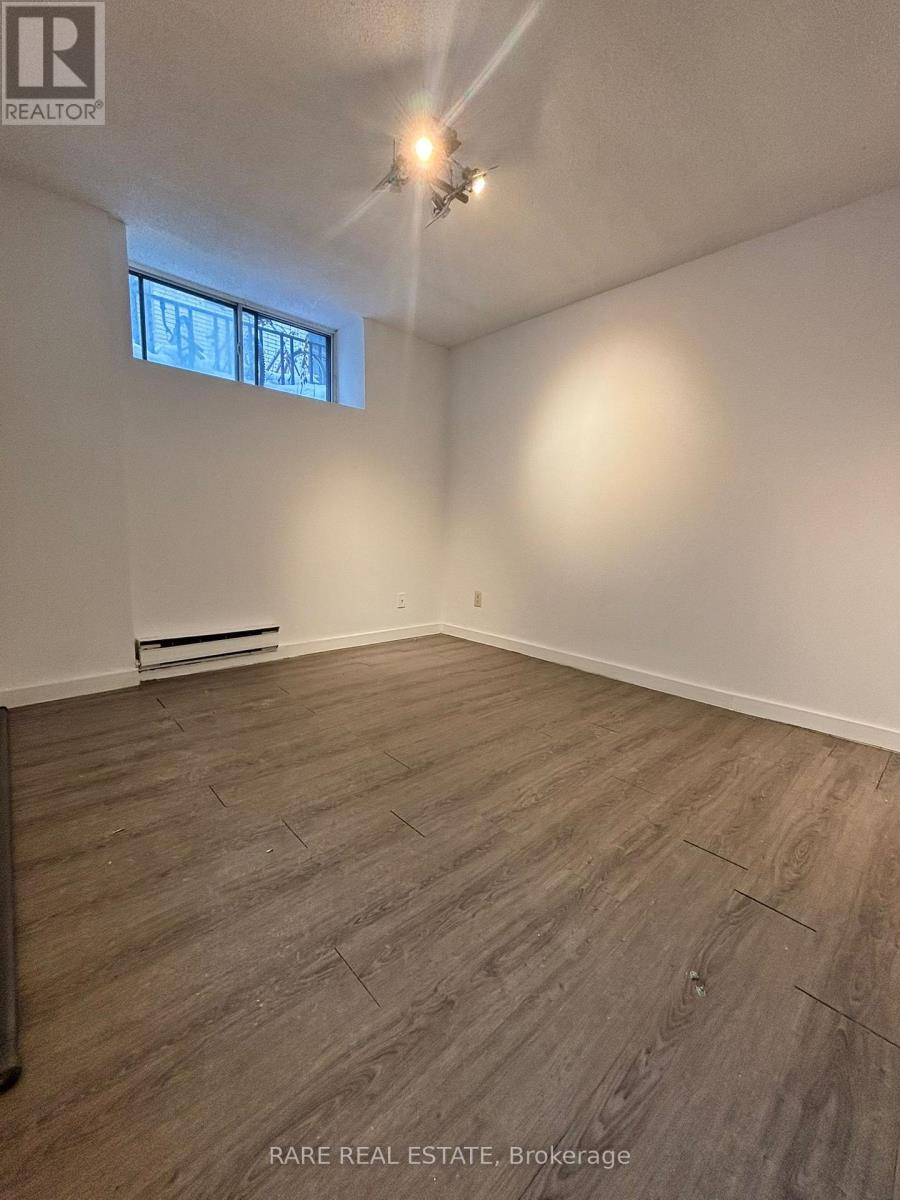 A room with wooden flooring and a window.