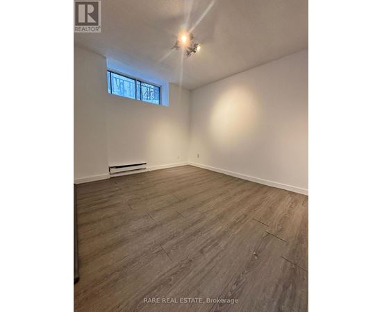 A room with wooden flooring and a window.