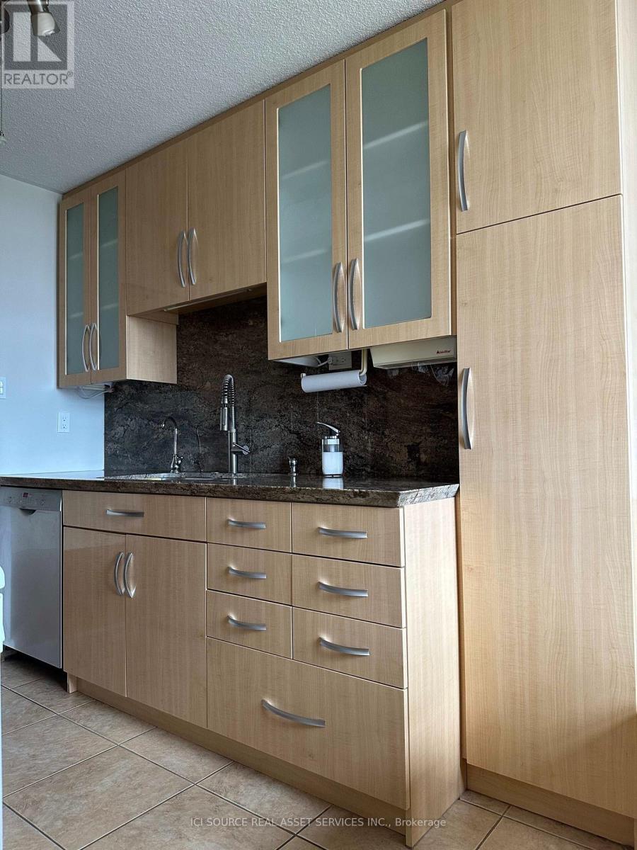 A kitchen with wooden cabinets and a black countertop.