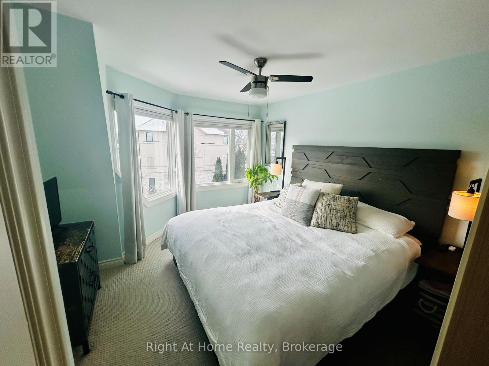 A bedroom with a large bed and a ceiling fan.
