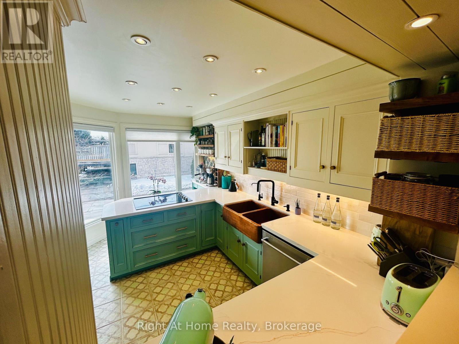 A kitchen with green cabinets and a white counter.