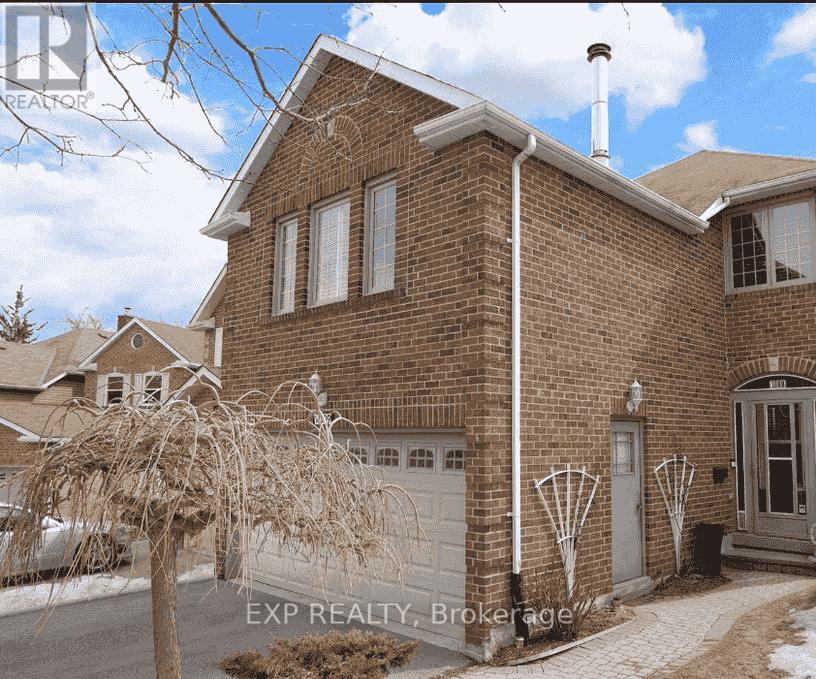 A brick house with a white garage door and a white pipe on the side.