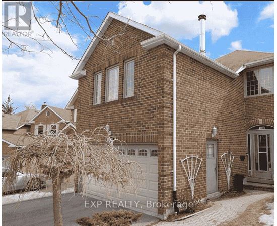 A brick house with a white garage door and a white pipe on the side.