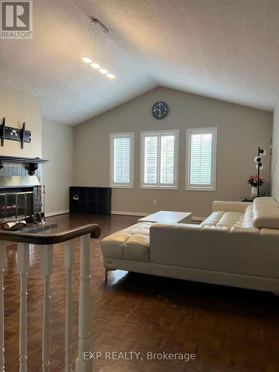 A living room with a couch, a fireplace, and a clock on the wall.