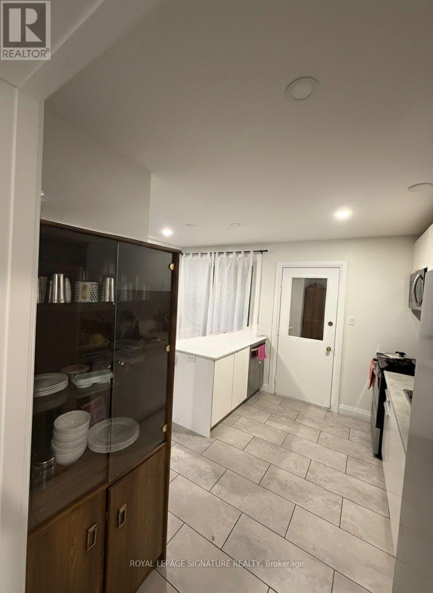 A kitchen with a refrigerator, cabinets, and a counter.